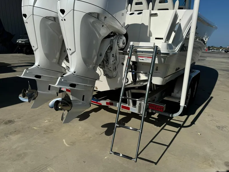 Slide: The Image of 2025 Sailfish 272 CC boat with dual outboard motors and ladder on trailer. - 6