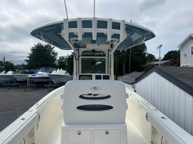 Slide: The Image of 2025 Cobia 240 Center Console boat with T-top, docked outdoors. - 12
