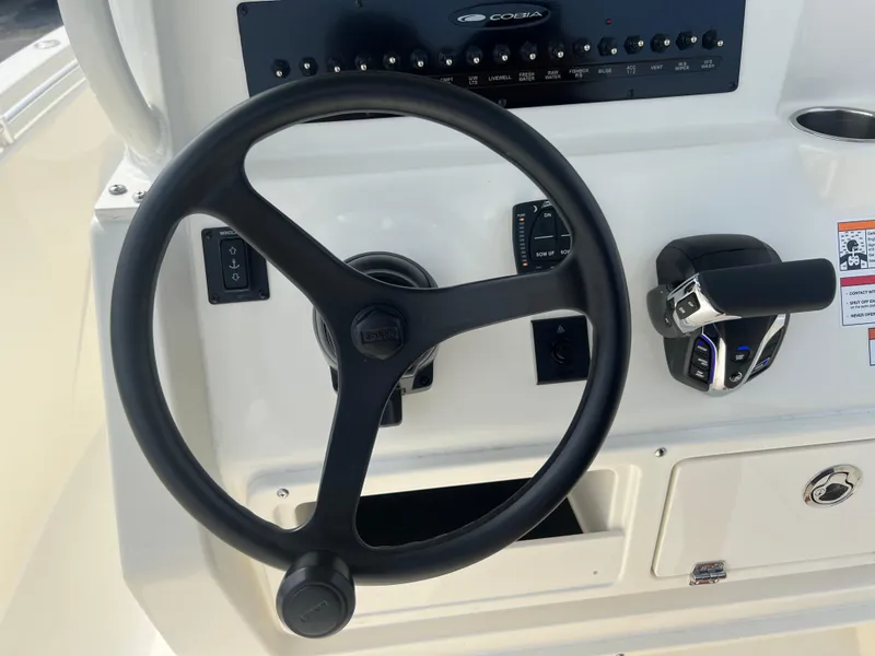 Slide: The Image of Steering wheel and controls of 2025 Cobia 240 Center Console boat. - 19