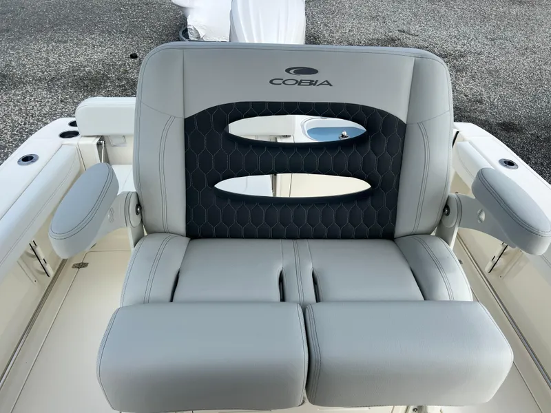 Slide: The Image of 2025 Cobia 240 Center Console boat seat with armrests and logo. - 22