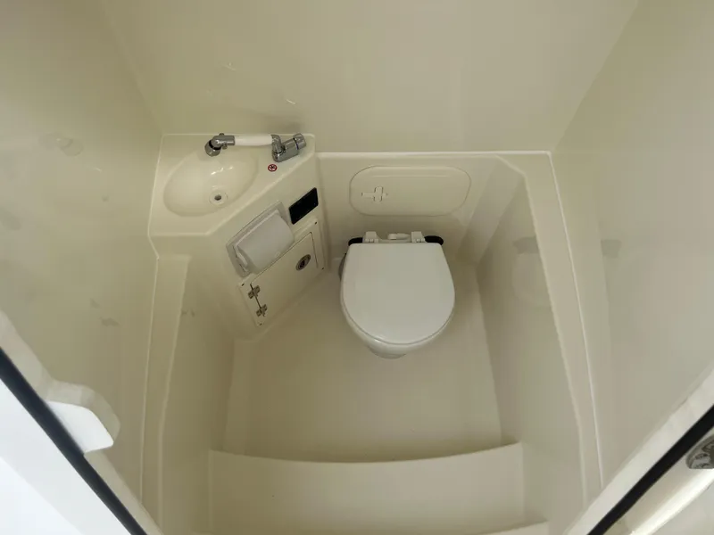 Slide: The Image of 2025 Cobia 240 Center Console boat bathroom with sink and toilet. - 25