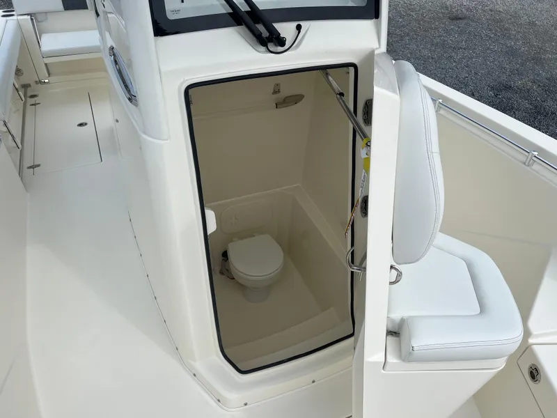 Slide: The Image of 2025 Cobia 240 Center Console boat with onboard toilet compartment. - 26