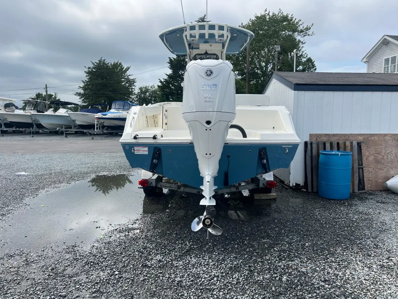 Slide: The Image of 2025 Cobia 240 Center Console boat in a gravel lot, rear view. - 3