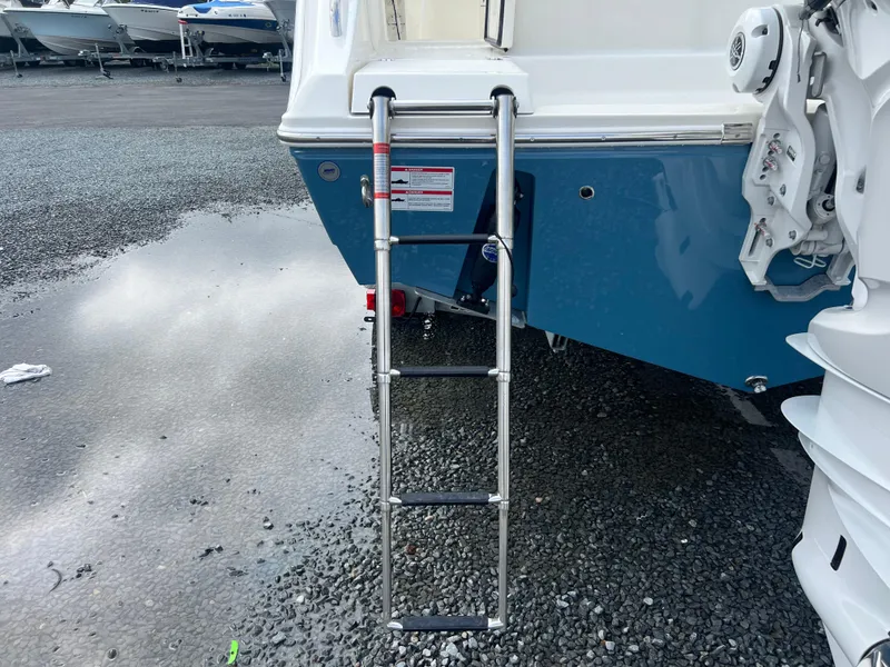 Slide: The Image of 2025 Cobia 240 Center Console boat with a metal boarding ladder. - 4