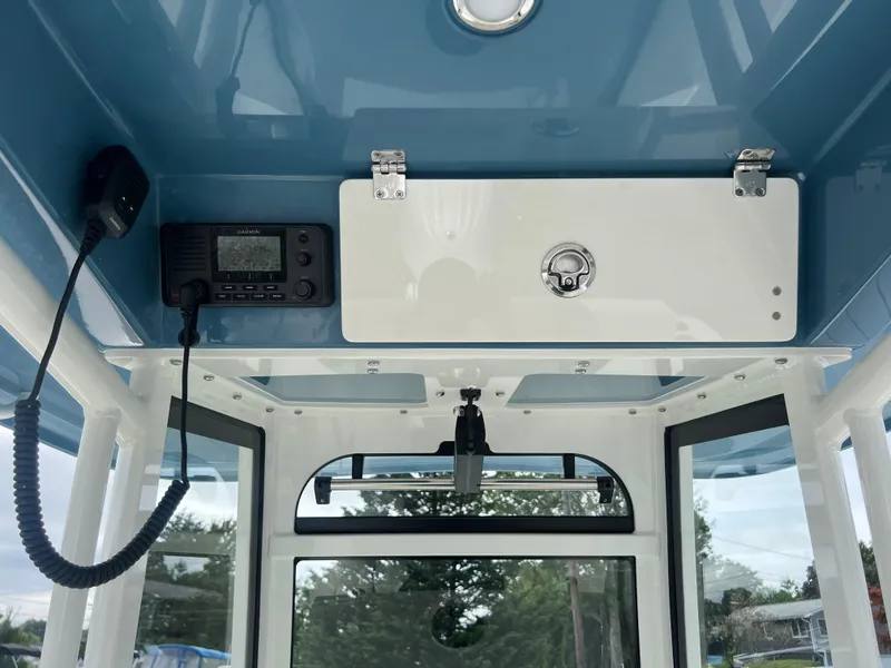 Slide: The Image of 2025 Cobia 240 Center Console boat interior with radio and storage compartment. - 5