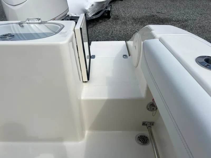 Slide: The Image of 2025 Cobia 240 Center Console boat interior, featuring sleek white seating and storage area. - 7