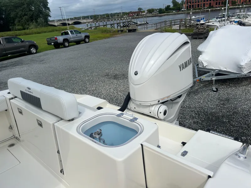 Slide: The Image of 2025 Cobia 240 Center Console boat with Yamaha outboard motor, dockside view. - 9