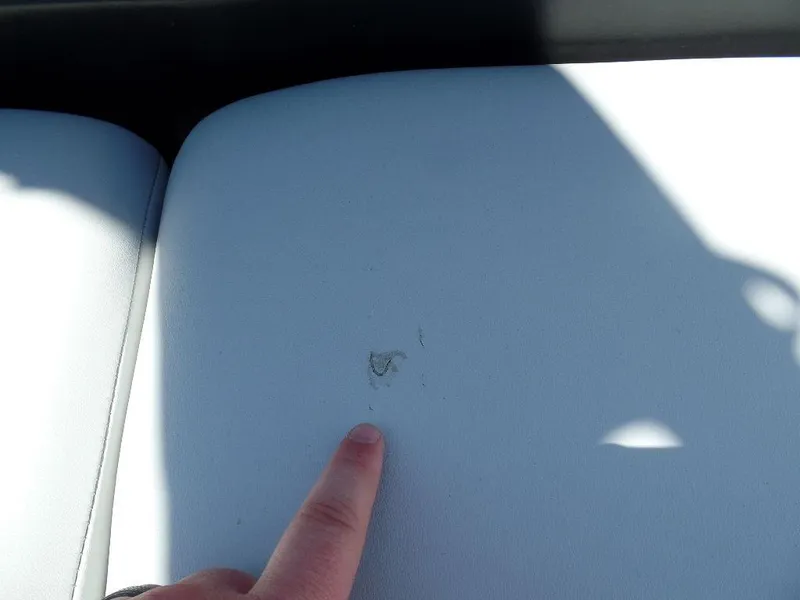 Slide: The Image of Finger pointing at a small tear on 2019 Axis A24 boat seat upholstery. - 10