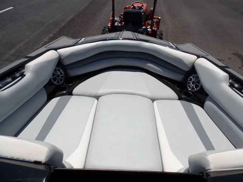 Slide: The Image of 2019 Axis A24 boat interior with gray and white seating, featuring cup holders and speakers. - 14