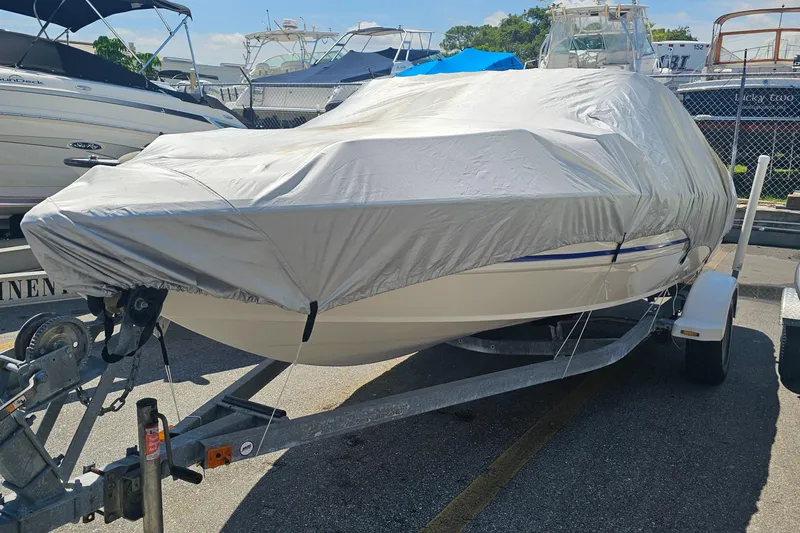 Slide: The Image of 2008 Stingray 185LS boat covered on trailer in marina parking lot. - 5