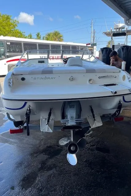Slide: The Image of 2008 Stingray 185LS boat, rear view, parked outdoors under clear blue sky. - 9