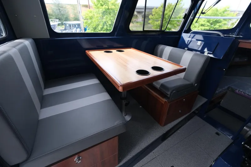Slide: The Image of 2024 Hewescraft 250 Pacific Explorer interior with seating and table, featuring cup holders. - 12