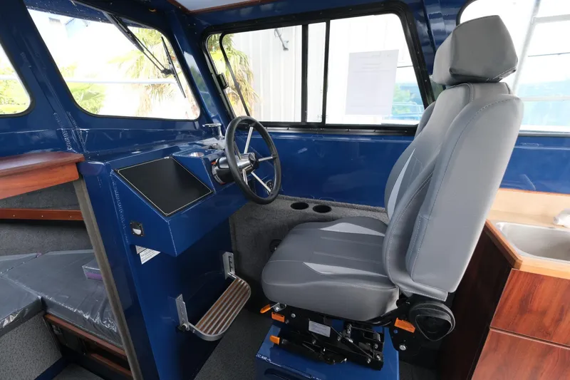 Slide: The Image of 2024 Hewescraft 250 Pacific Explorer interior with steering wheel and captain's chair. - 14