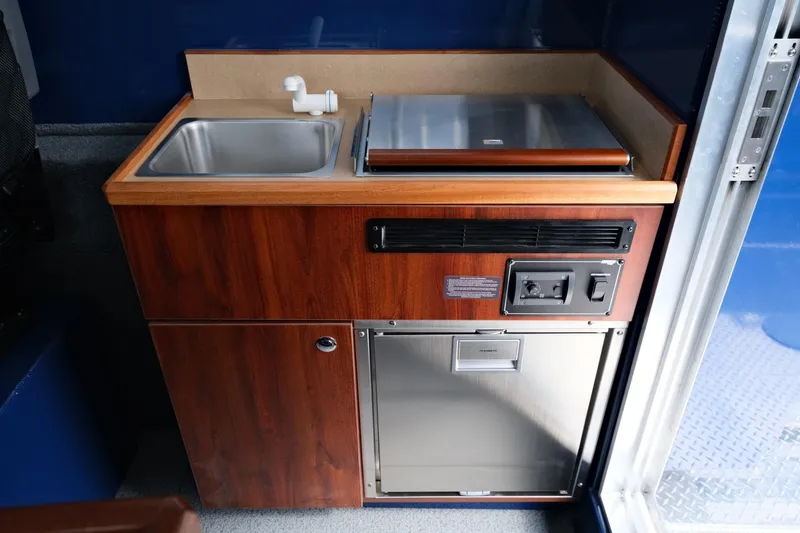 Slide: The Image of 2024 Hewescraft 250 Pacific Explorer kitchenette with sink and stove. - 17