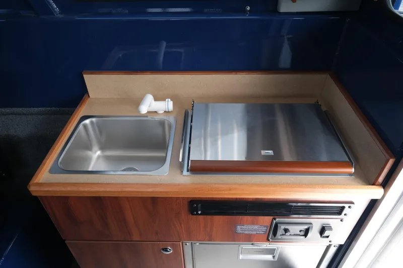 Slide: The Image of 2024 Hewescraft 250 Pacific Explorer kitchenette with sink and stove. - 18