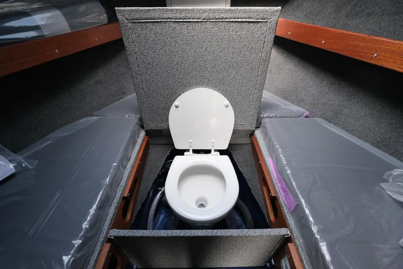 Slide: The Image of 2024 Hewescraft 250 Pacific Explorer interior with built-in marine toilet. - 19