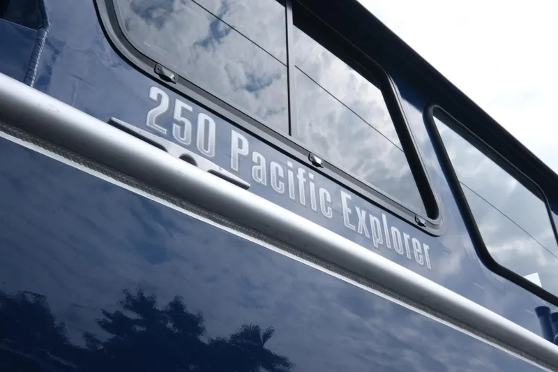Slide: The Image of 2024 Hewescraft 250 Pacific Explorer boat exterior with reflective windows. - 6