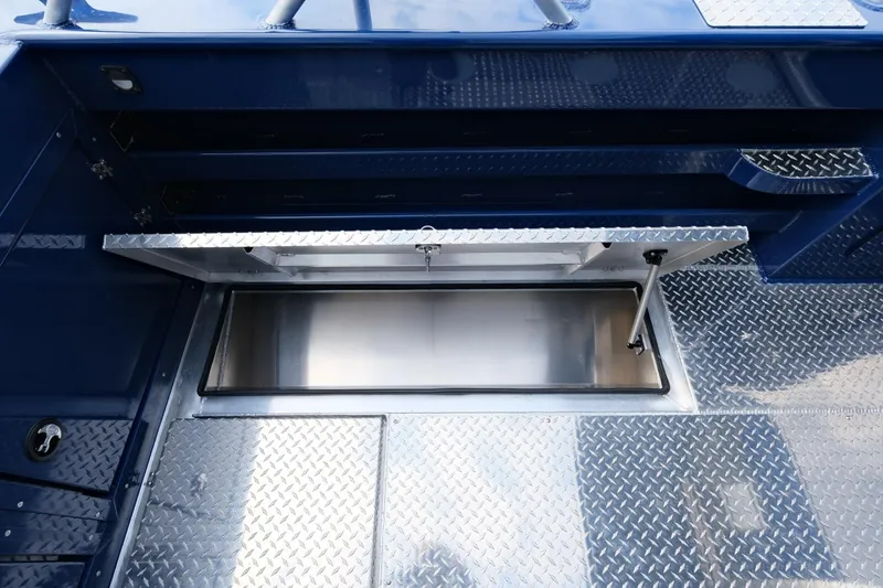 Slide: The Image of 2024 Hewescraft 250 Pacific Explorer boat with open storage compartment and diamond plate flooring. - 9