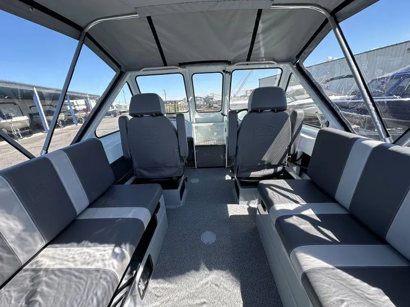 Slide: The Image of 2024 Hewescraft 210 Sea Runner interior with gray seating and spacious cabin design. - 5
