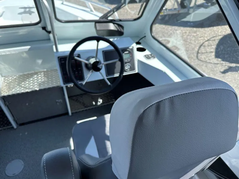 Slide: The Image of 2024 Hewescraft 210 Sea Runner w/ET boat interior, featuring steering wheel and dashboard controls. - 6