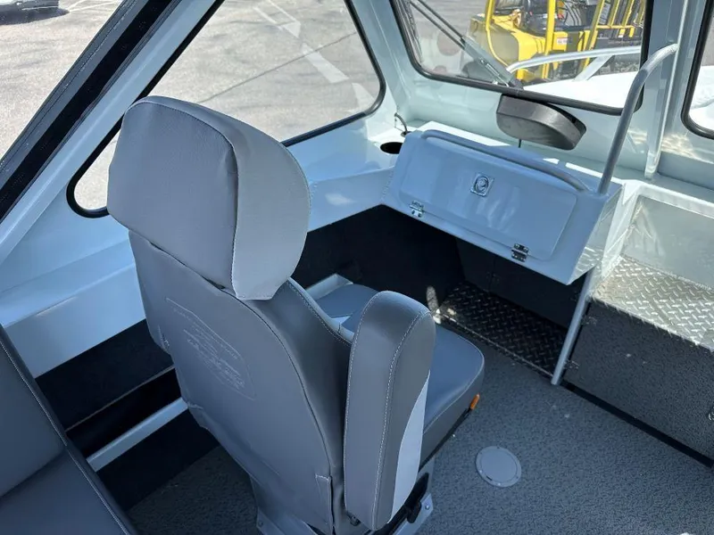 Slide: The Image of 2024 Hewescraft 210 Sea Runner interior with gray seating and dashboard view. - 7