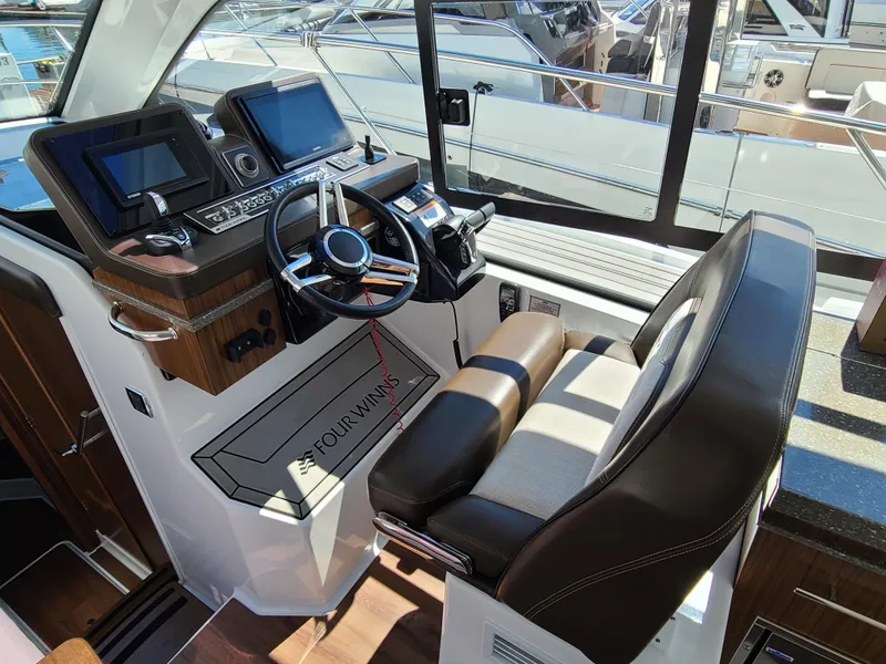 Slide: The Image of 2021 Four Winns Vista 355 Coupe OB helm with modern controls and leather seating. - 10