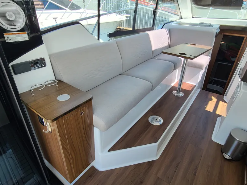 Slide: The Image of 2021 Four Winns Vista 355 Coupe OB interior with sleek seating and wooden accents. - 11