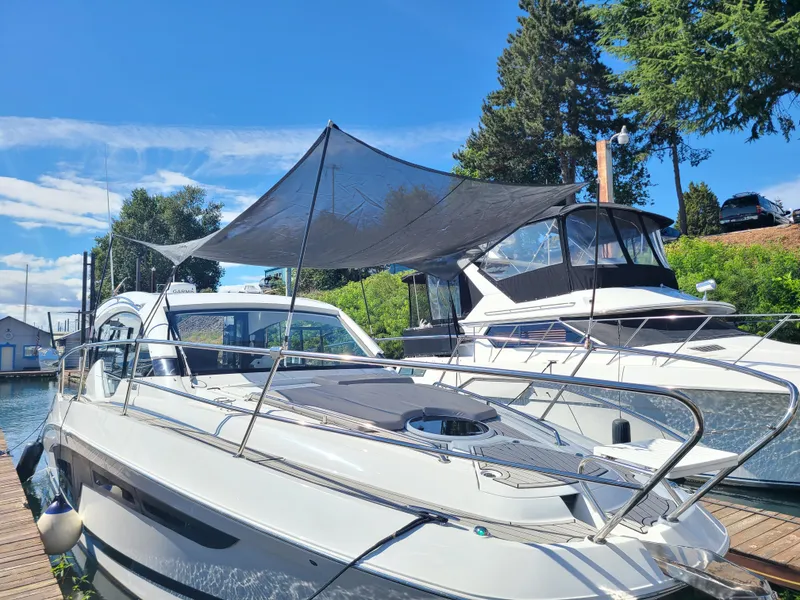Slide: The Image of 2021 Four Winns Vista 355 Coupe OB docked, featuring sleek design and sunshade canopy. - 7