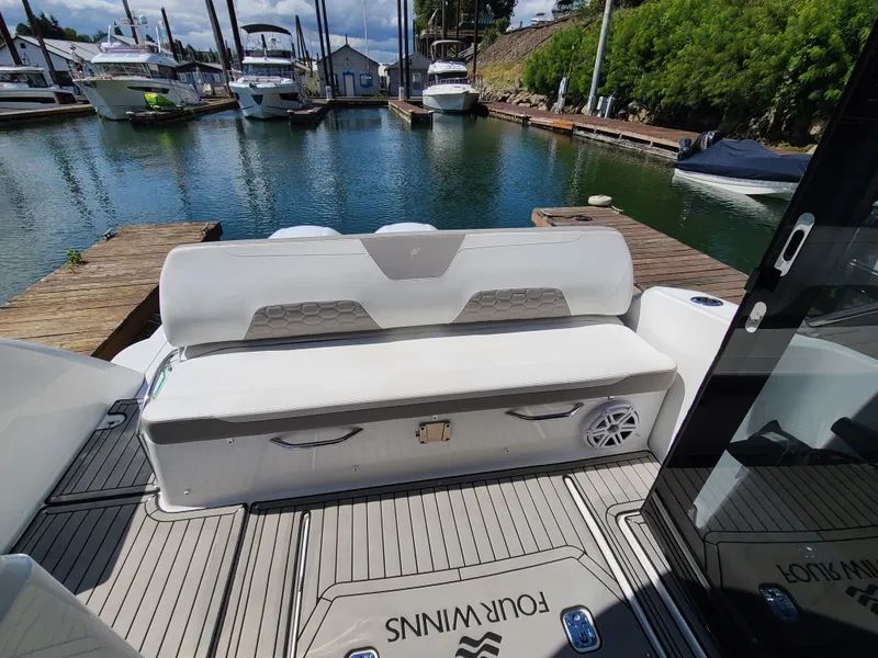 Slide: The Image of 2021 Four Winns Vista 355 Coupe OB at marina, featuring rear seating and deck. - 8