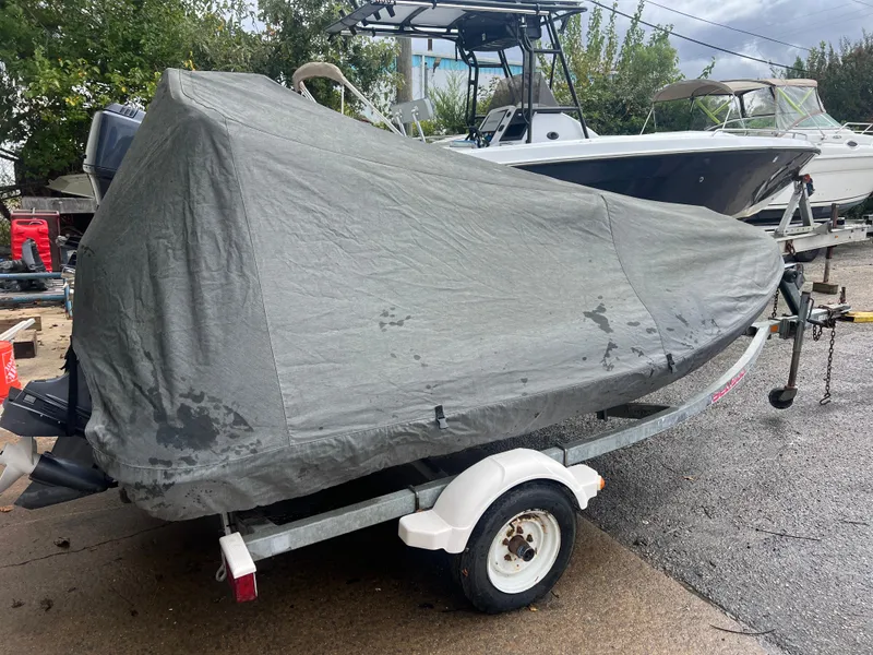 Slide: The Image of 2017 Walker Bay Generation 340 DLX boat covered on trailer in outdoor setting. - 16