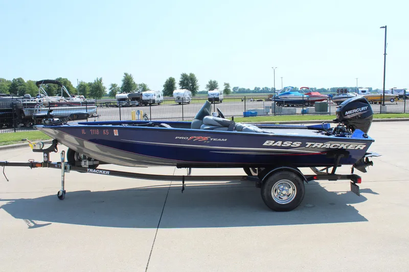 Slide: The Image of 2015 Tracker Pro Team 175 TF bass boat on trailer in parking lot. - 4