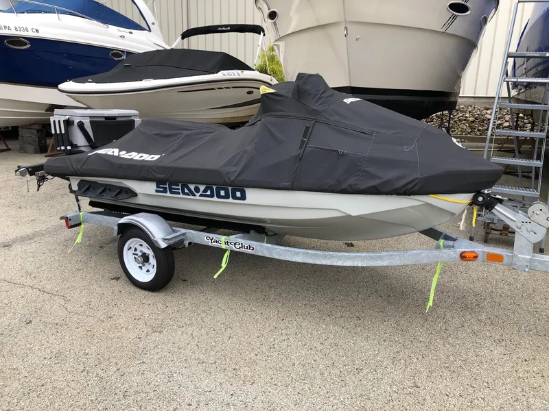 Slide: The Image of 2021 Sea-Doo FISH PRO 170 on trailer, covered, parked near boats. - 2