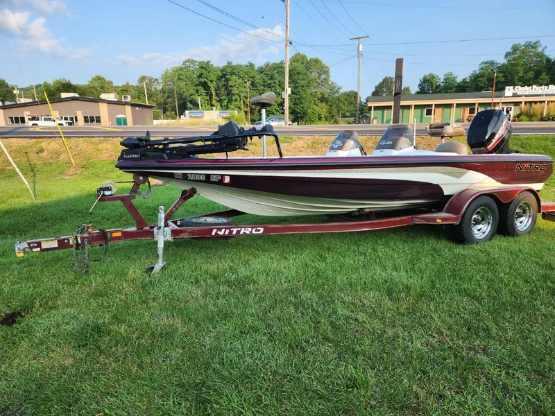 Slide: The Image of 2001 Nitro 896 DC boat on trailer, parked on grass, sunny day. - 2