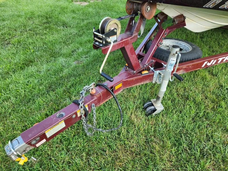 Slide: The Image of Nitro 896 DC 2001 boat trailer hitch on grass, featuring winch and safety chains. - 7