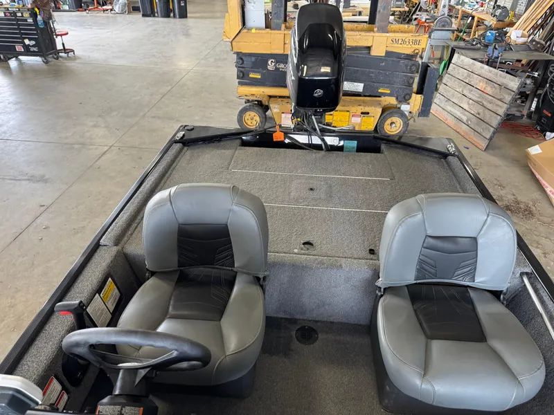 Slide: The Image of 2021 Tracker Bass Tracker Classic XL boat interior with two gray seats in a workshop. - 11