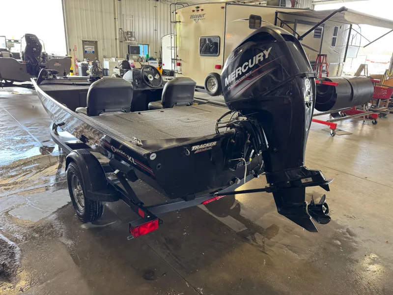 Slide: The Image of 2021 Tracker Bass Tracker Classic XL boat with Mercury engine in a garage setting. - 4