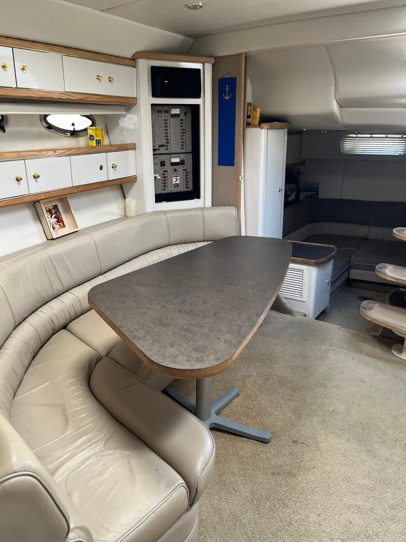 Slide: The Image of Interior of a 1996 Maxum 4100 SCR yacht with beige seating and a dining table. - 13