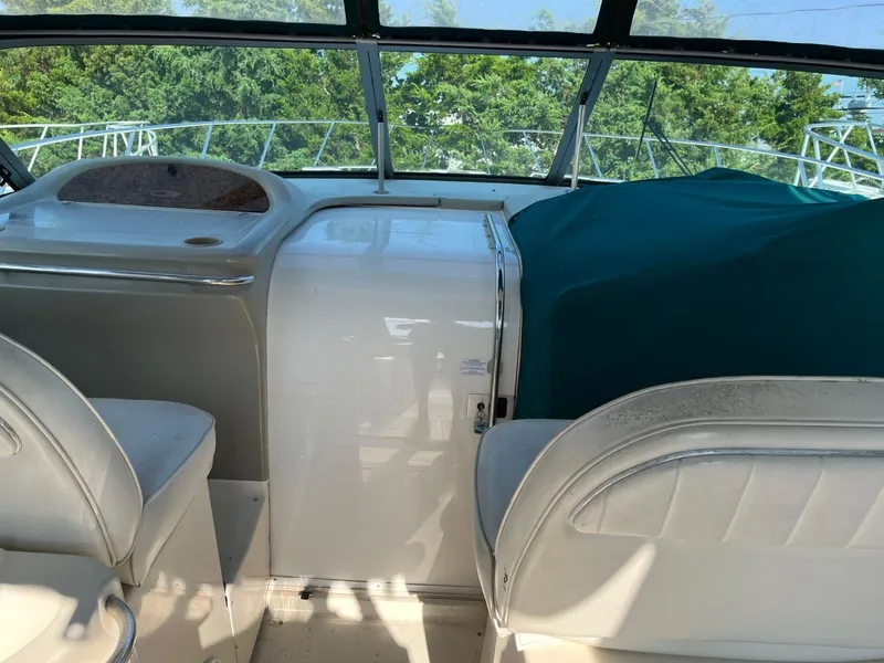 Slide: The Image of 1996 Maxum 4100 SCR yacht interior with white seating and covered dashboard. - 8