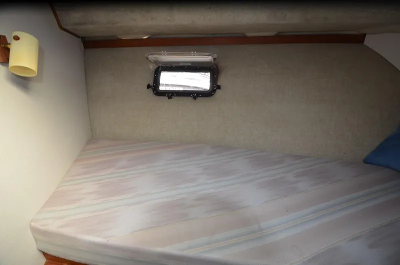 Slide: The Image of 1988 Carver 3207 cabin interior with bed, porthole, and wall lamp. - 10