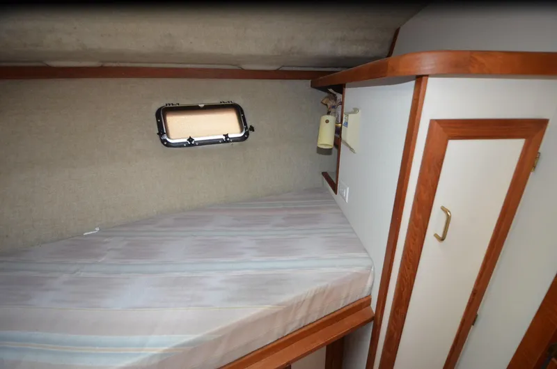 Slide: The Image of 1988 Carver 3207 cabin interior with bed, window, and wooden accents. - 11