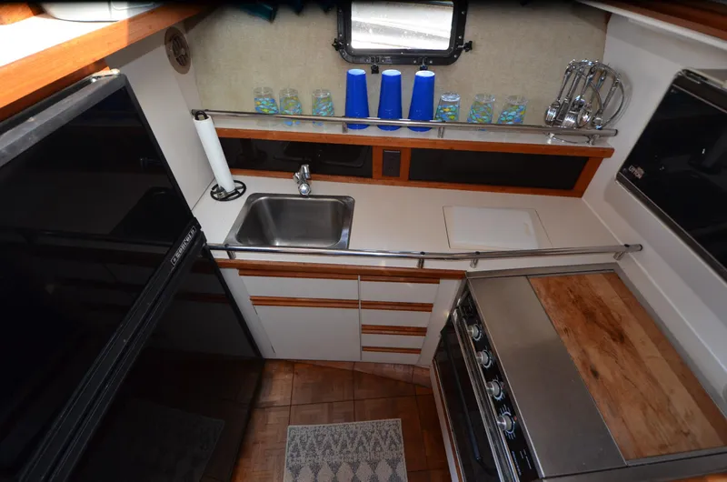 Slide: The Image of 1988 Carver 3207 yacht kitchen with sink, stove, and storage cabinets. - 12