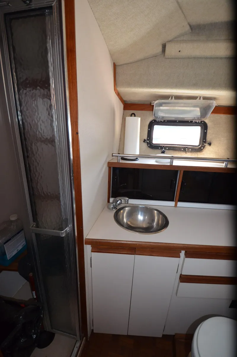 Slide: The Image of 1988 Carver 3207 boat bathroom with sink, shower, and storage cabinets. - 15