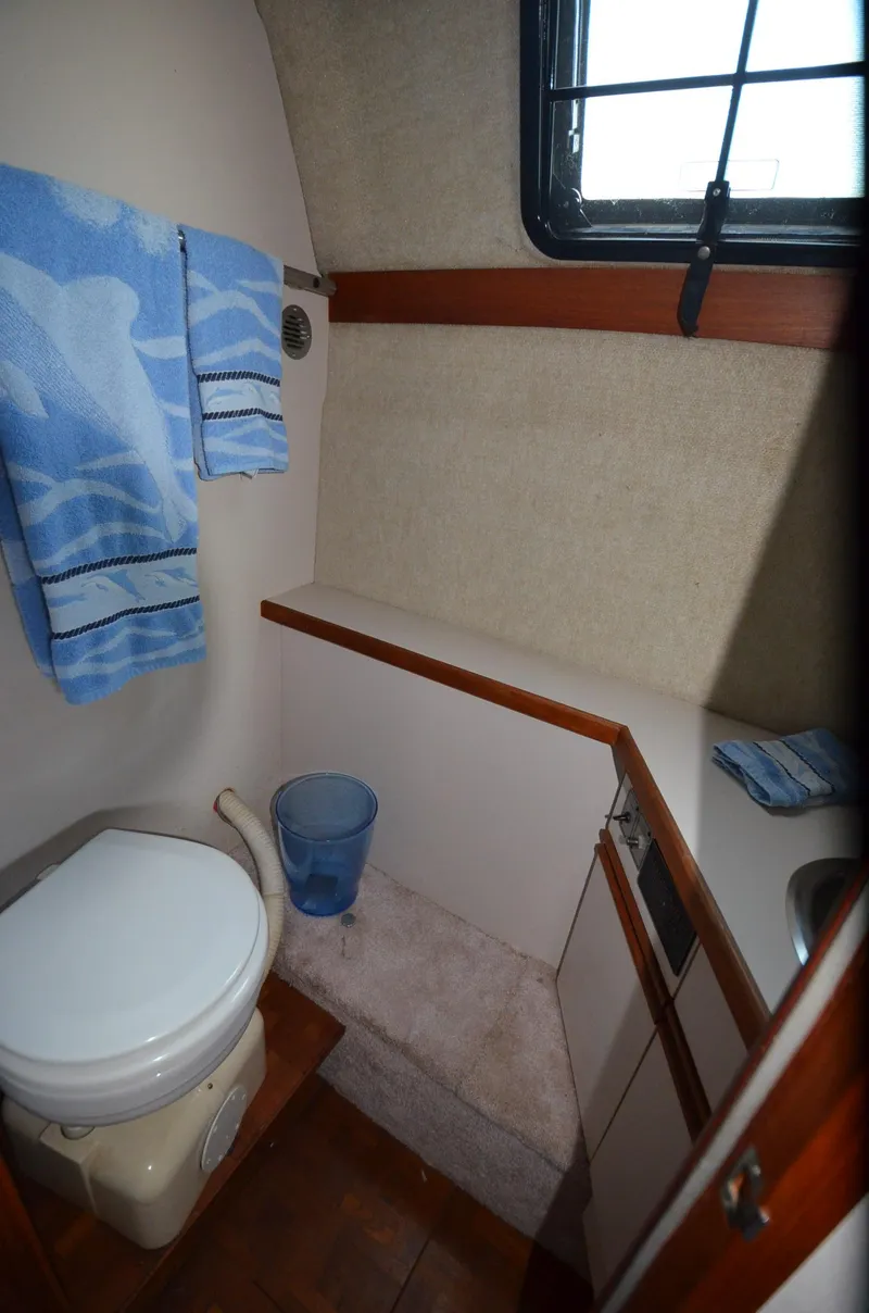 Slide: The Image of 1988 Carver 3207 boat bathroom with toilet, towels, and window. - 19