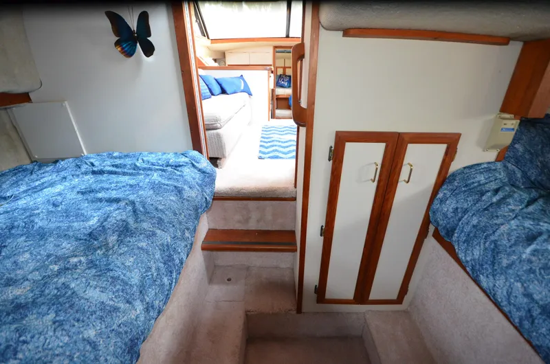 Slide: The Image of Interior of 1988 Carver 3207 yacht with blue bedding and wooden accents. - 20