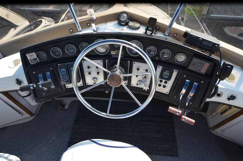 Slide: The Image of 1988 Carver 3207 boat dashboard with steering wheel and control panel. - 3