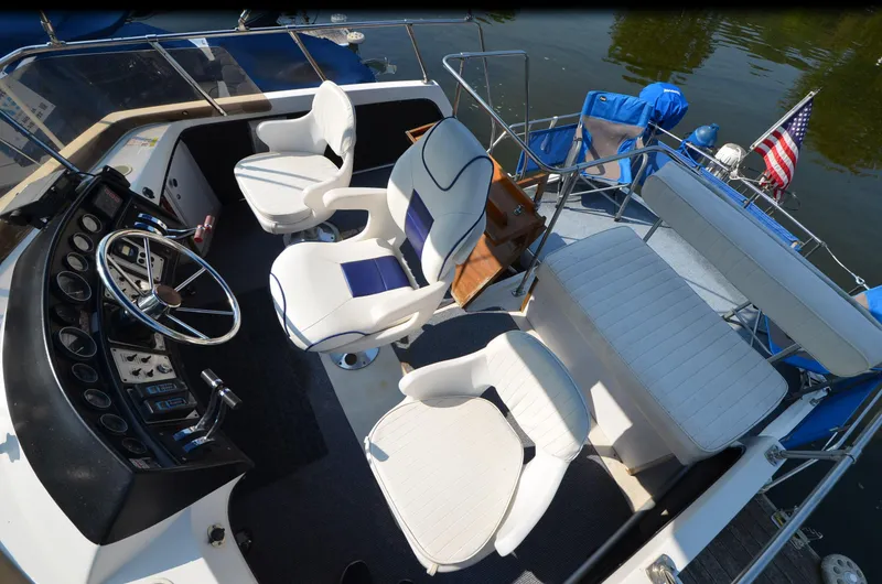 Slide: The Image of 1988 Carver 3207 boat interior with steering wheel, seating, and American flag. - 4