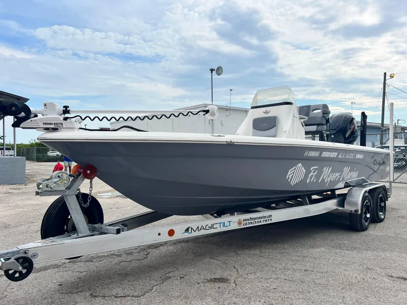 Slide: The Image of 2023 NauticStar 227 XTS boat on trailer, displayed outdoors under cloudy sky. - 14