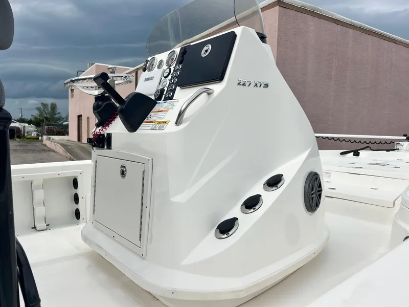 Slide: The Image of 2023 NauticStar 227 XTS boat console with controls and storage compartment. - 5