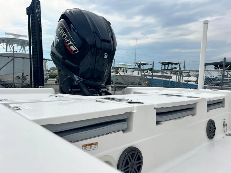 Slide: The Image of 2023 NauticStar 227 XTS boat with powerful outboard motor, docked under cloudy skies. - 6
