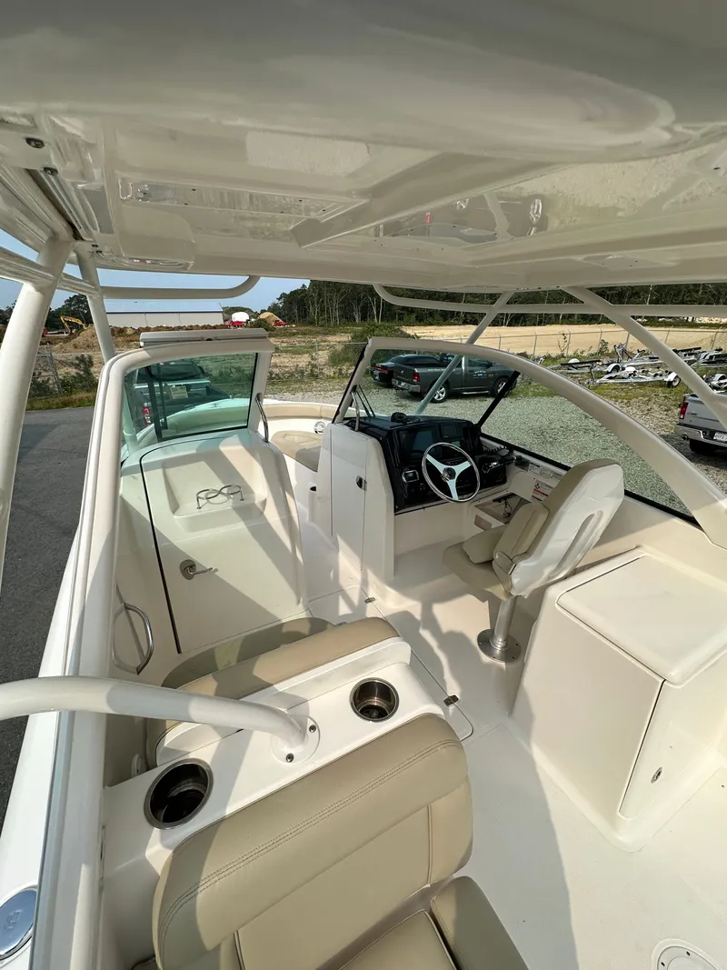 Slide: The Image of 2016 Pursuit DC 265 Dual Console boat interior with seating and steering wheel. - 11